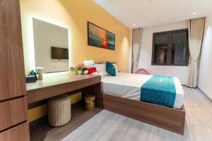 a bedroom with a bed and a desk in it at X-Men Hotel Thanh Hoa - Not Near Sam Son Beach in Thanh Hóa