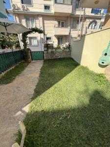 a backyard of a building with a guitar on the grass at Sahil Apart in Datca