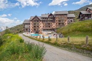 a large building on a hill with a pool at Résidence Pierre & Vacances Le Thabor in Valmeinier