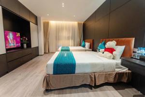 a large bedroom with a teddy bear sitting on a bed at X-Men Hotel Thanh Hoa - Not Near Sam Son Beach in Thanh Hóa +16 photos