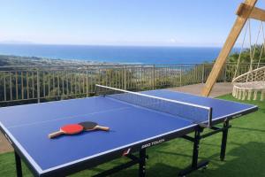a ping pong table on a balcony with the ocean at Great Escape Sea View Private Pools, Jacuzzi & Ultimate Relaxation in Maroulás