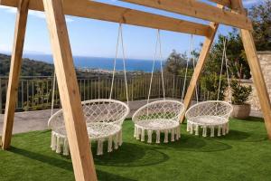a group of chairs sitting on a swing at Great Escape Sea View Private Pools, Jacuzzi & Ultimate Relaxation in Maroulás