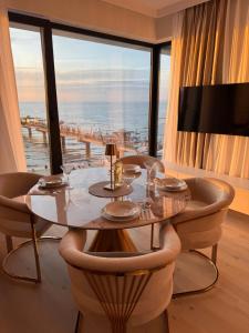 a dining room with a table and a large window at Baltic Infinity Resort&Spa Apartament Dworek in Międzyzdroje