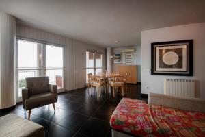 a living room with a couch and a table and chairs at Apartament Marina Roses 3 in Roses
