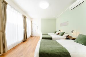 a hotel room with three beds and a couch at Shimabara 結 Terrace in Shimabara