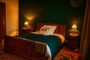 a bedroom with a bed with green walls and two lamps at Chez jacky in Serres