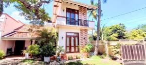 a house with a red door and trees at Retraite soleil sérénité in Pamunugama
