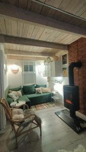 a living room with a green couch and a fireplace at Izbicki ZaKątek- Izbica nad jeziorem Łebsko in Speck