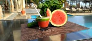 a drink sitting on a table with a slice of watermelon at Retraite soleil sérénité in Pamunugama