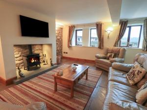 a living room with a couch and a fireplace at Orcaber Farm Barn in Lancaster