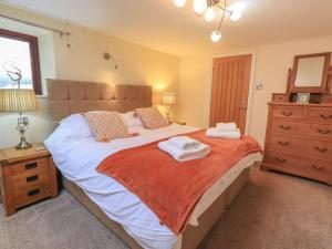 a bedroom with a large bed with towels on it at Orcaber Farm Barn in Lancaster