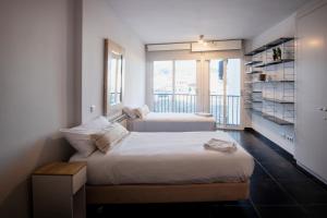 two beds in a room with a large window at Apartament Marina Roses 3 in Roses