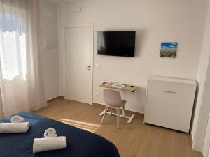a bedroom with a bed and a desk with a computer at OTB ITALIA - Airport Rooms in Treviso