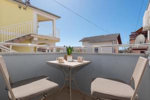 a small table and two chairs on a balcony at Studio Apartments Lovrić in Vodice