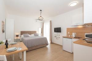 a bedroom with a bed and a kitchen with a table at Studio Apartments Lovrić in Vodice