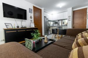 a living room with a couch and a tv at Departamento full equipado Pucón - Casa Ayun in Pucón
