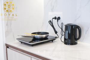 a kitchen counter with a pan and a coffee pot at Royal Suites 2BR - Formosa Residence in Jodoh