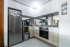 a kitchen with a stainless steel refrigerator and appliances at Departamento full equipado Pucón - Casa Ayun in Pucón