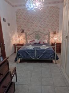 a bedroom with a bed with a blue comforter at Casa Valia in Carloforte