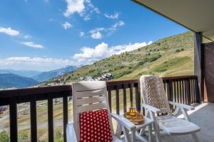 two chairs on a balcony with a view of a mountain at Résidence Pierre & Vacances Le Thabor in Valmeinier +35 photos