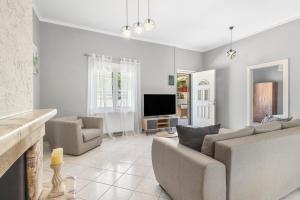 a living room with a couch and a television at Martas Dream - Near Beach 2 Bedroom Deluxe Apartment in Daratso +9 photos
