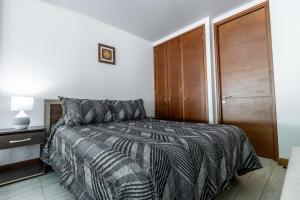 a bedroom with a bed and a wooden closet at Departamento full equipado Pucón - Casa Ayun in Pucón +19 photos