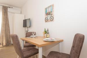a dining room with a wooden table and chairs at Studio Apartments Lovrić in Vodice