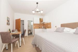 a bedroom with a bed and a desk and a kitchen at Studio Apartments Lovrić in Vodice