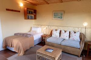 a bedroom with a bed and a couch in a room at Bergplaas Nature Reserve in Nieu-Bethesda