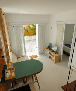a living room with a green table and a television at Pakuhaji Highland Ecoresort in Panjadakan