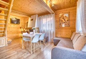 a living room with a table and chairs and a couch at Domek ANITA in Polańczyk