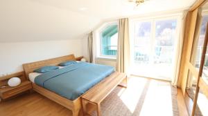 a bedroom with a bed and a large window at Vienna Woods Residence in Gaaden