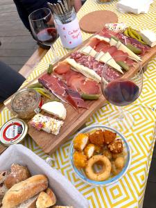 a table with a bunch of food and a glass of wine at Amis Wine House - Maison d'hôtes à 5 min de Saint-Émilion in Pomerol