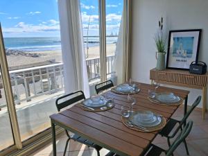 a dining room with a table with a view of the beach at Horizon Bleu Duplex 2 chambres vue mer in Palavas-les-Flots