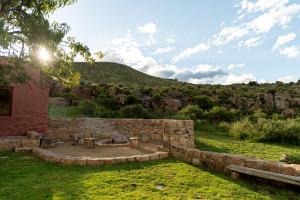 a fire pit in a yard with a hill in the background at Bergplaas Nature Reserve in Nieu-Bethesda