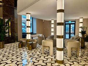 a lobby with columns and chairs in a building at Aria Palace by OMNIA hotels in Rome
