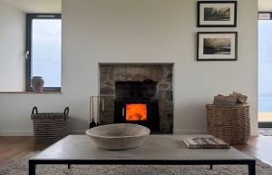 a living room with a fireplace and a table at Taigh Druim in Elgol