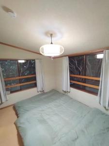 a small bedroom with a bed and two windows at Mount Villa Atami in Kannami