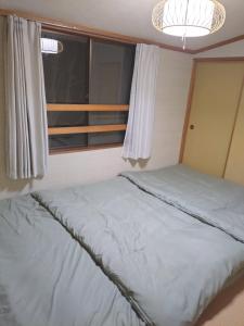 a bed in a small room with a window at Mount Villa Atami in Kannami