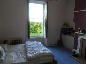 a bedroom with a bed in front of a window at OYO Ashlea Manor in Monifieth +5 photos