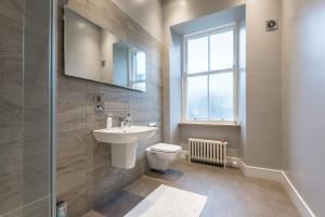a bathroom with a sink and a toilet and a mirror at OYO Ashlea Manor in Monifieth