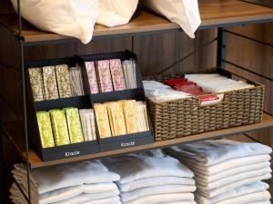 a shelf filled with books and wicker baskets at Hotel ARM ObihiroEkimae in Obihiro