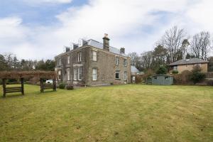 an old house with a large yard in front of it at OYO Ashlea Manor in Monifieth