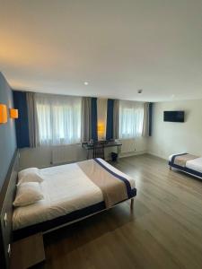 a large bedroom with two beds and a desk at Hôtel Valpré in Écully +34 photos
