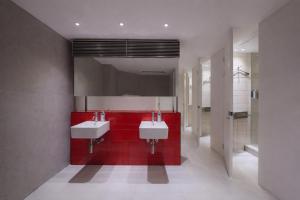 a bathroom with two sinks and a red wall at At gangnam seoul in Seoul