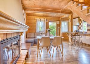 a dining room and living room with a fireplace at Domek ANITA in Polańczyk