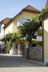 a building with a tree on the side of a street at Weingut Martin Blaß in Erlabrunn