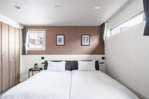 two beds in a small room with two windows at Gran Hills in Chitose