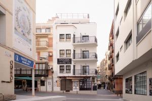 a white building with balconies on a city street at Estudios RH Sol in Benidorm