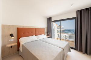 a bedroom with a large bed and a balcony at Estudios RH Sol in Benidorm +12 photos